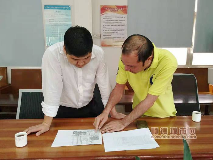 北滘镇党委副书记陈林（左）与三洪奇党委副书记吴锡桐研究三洪奇的村改工作.jpg