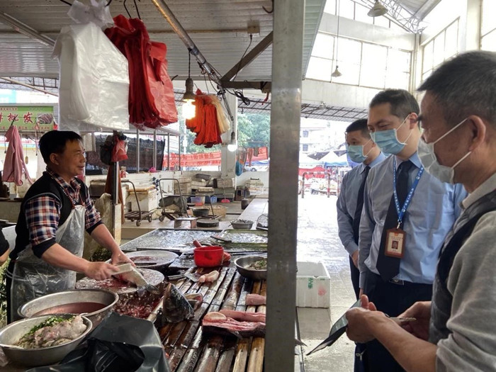 区市场监督管理局党员干部到农贸市场检查是否存在违规经营野生动物等情况，同时要求档主佩戴口罩，加强个人防护。.jpg