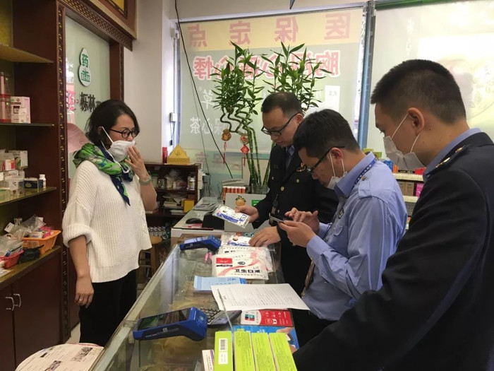 区市场监督管理局执法人员对群众举报的药店经营者哄抬口罩等药品用品价格行为进行现场检查。.jpg