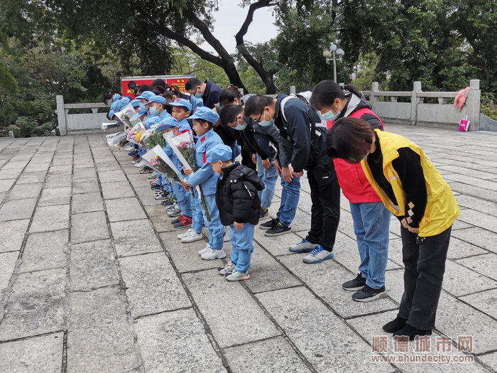 学生们穿上八路军军服与家长们一起为革命烈士纪念碑献上鲜花.jpg