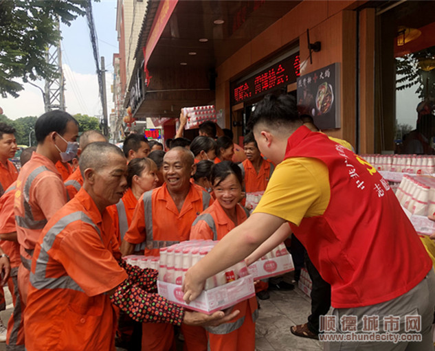 志愿者为环卫工派发清凉饮料。.jpg