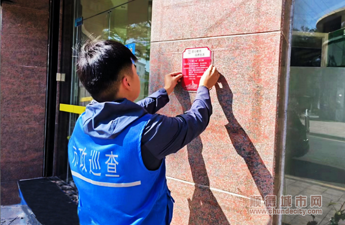 市政巡查人员张贴“门前三包”告示牌。.png