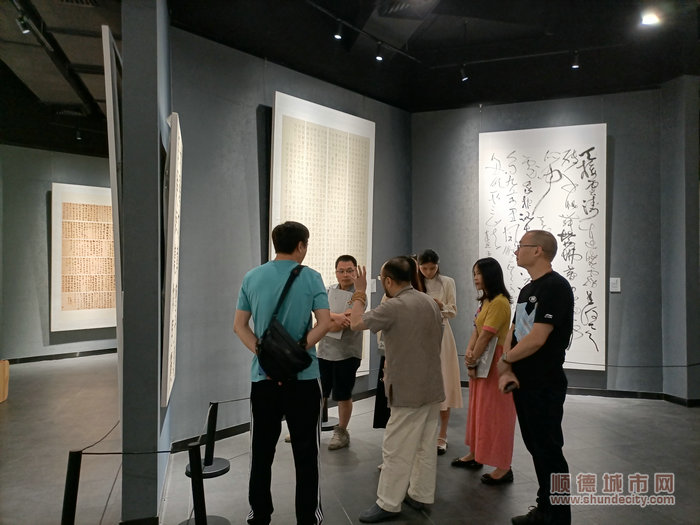 书法爱好者探讨结业展作品。.jpg