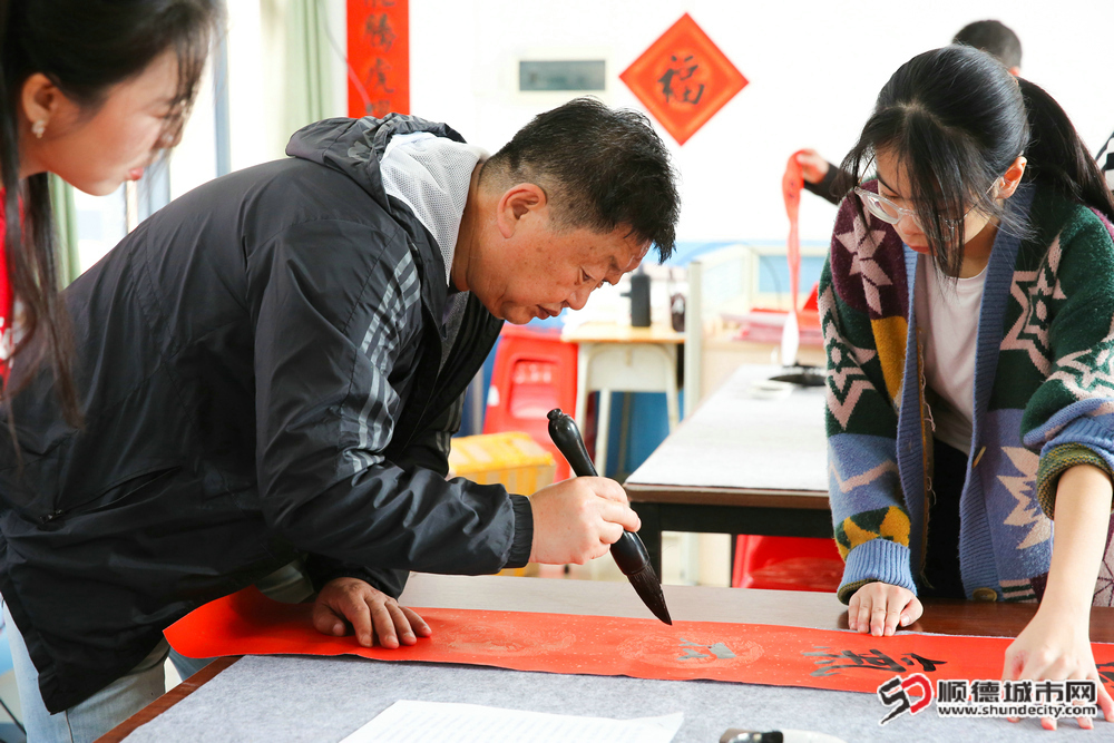陈村职业技术学校积极组织有书法专长的师生志愿者书写春联赠予此次慰问对象1.jpg