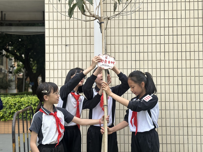 学生给新种树木挂上树苗牌。.jpg